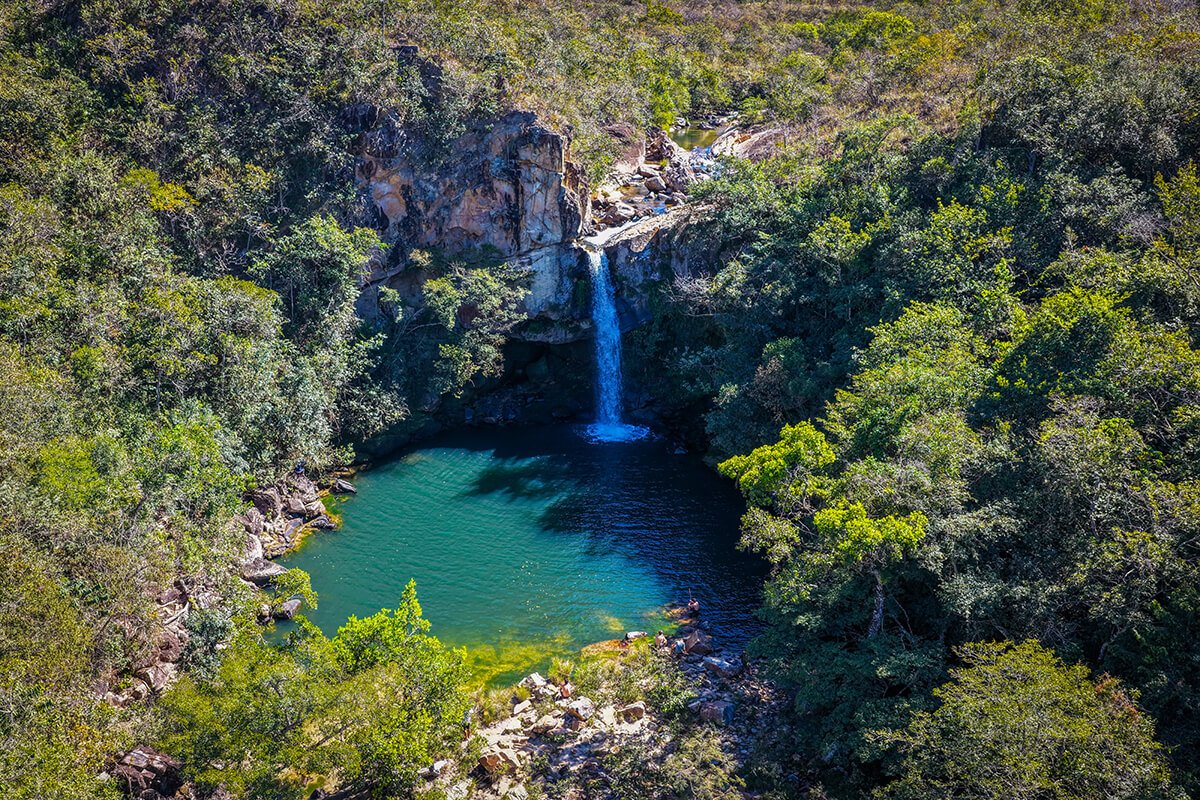 Vista aérea de cachoeira com poço de água cristalina cercado por mata no Complexo do Baú, em Delfinópolis/MG